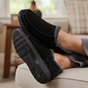 Man Sitting On Couch Wearing Orthofeet Vito Men's Slipper in Black