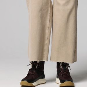 Woman Wearing Sorel Whitney III Mid WP in Red Lodge/Black with Tan Pants